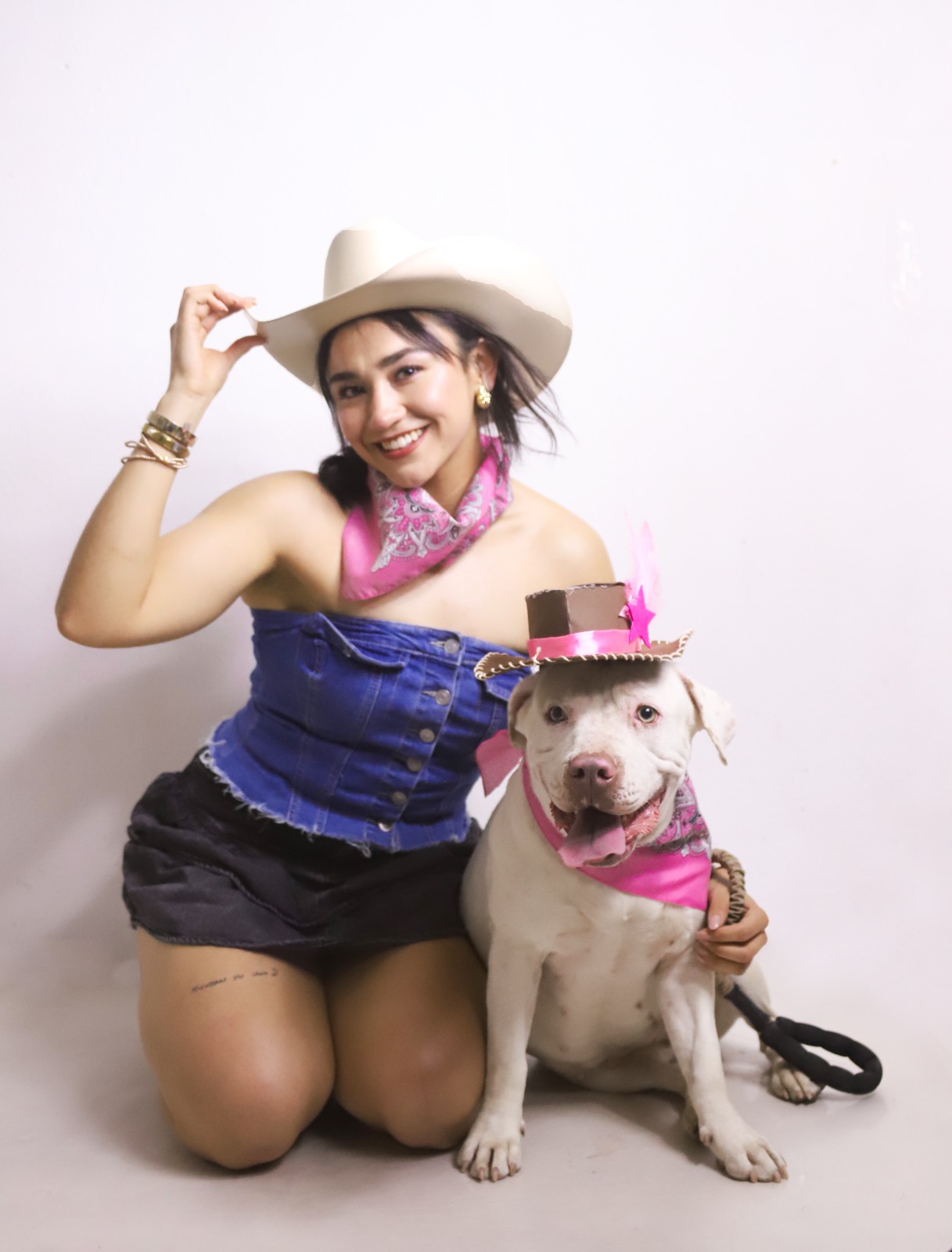 Mujer con sombrero vaquero acompañada de su perro en el estudio.