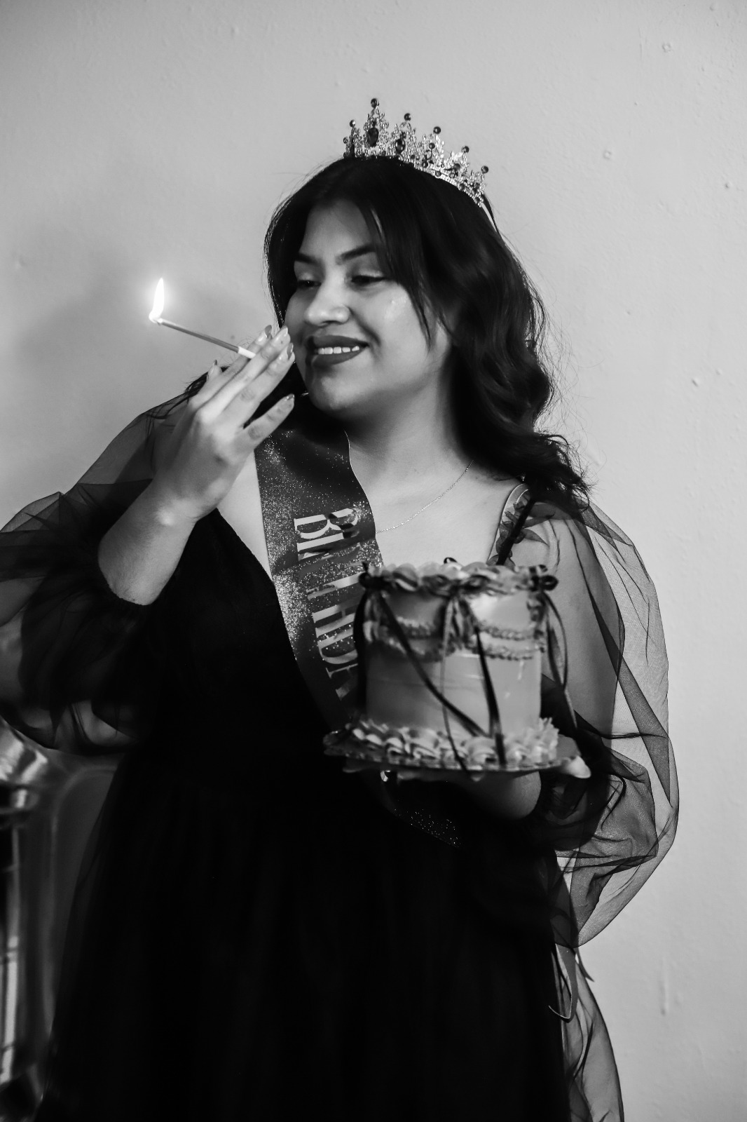Retrato en blanco y negro de una mujer con corona y pastel de cumpleaños.